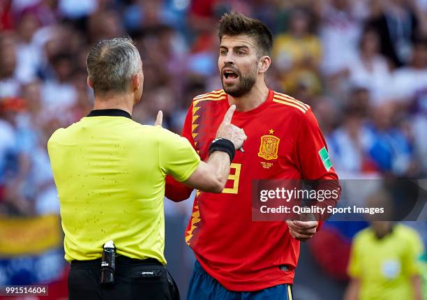 Gerard Pique of Spain of Spain argues with referee Bjorn Kuipers after he awards Russia with a penalty following a handball during the 2018 FIFA...