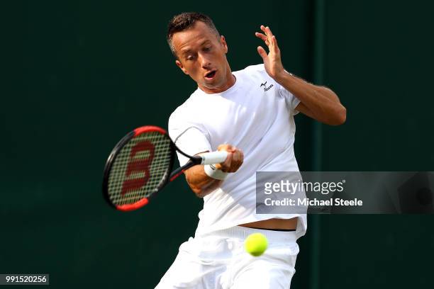 Philipp Kohlschreiber of Germay returns against Gilles Muller of Luxembourg on day three of the Wimbledon Lawn Tennis Championships at All England...