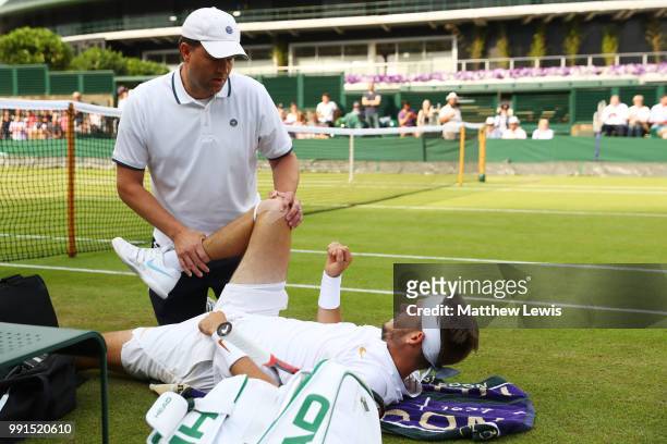 Jared Donaldson of the United States is treated for an injury during his Men's Singles second round match against Stefanos Tsitsipas of Greece on day...