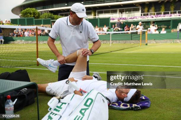 Jared Donaldson of the United States is treated for an injury during his Men's Singles second round match against Stefanos Tsitsipas of Greece on day...