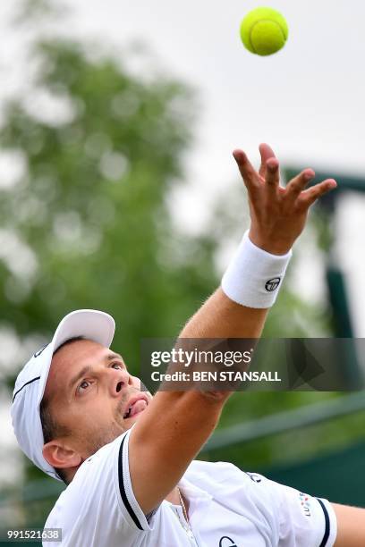 Luxembourg's Gilles Muller throws the ball to serve against Germany's Philipp Kohlschreiber during their men's singles second round match on the...