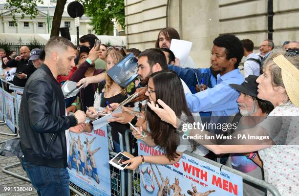 Tom Hardy signs autographs for fans during the Swimming with Men premiere held at Curzon Mayfair, London.