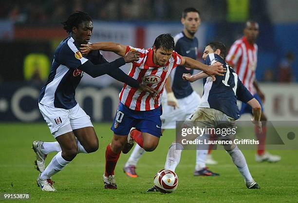 Sergio Aguero of Atletico Madrid is challenged by Zoltan Gera and Dickson Etuhu of Fulham during the UEFA Europa League final match between Atletico...