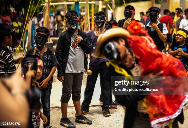 June 2018, Mexico, San Pedro Huamelula: Masked people dance on the sidelines of the celebrations in honor of San Pedro. As part of the celebrations,...