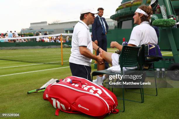 Stefanos Tsitsipas of Greece is treated for an injury during his Men's Singles second round match against Jared Donaldson of the United States on day...