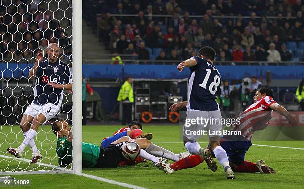 Sergio Aguero of Atletico Madrid tries to score against goalkeeper Mark Schwarzer of Fulham while Aaron Hughes tries to stop him during the UEFA...