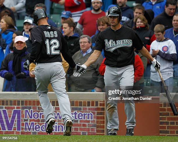 Cody Ross of the Florida Marlins is greeted by teammate Gaby Sanchez after scoring a run in the 9th inning against the Chicago Cubs at Wrigley Field...