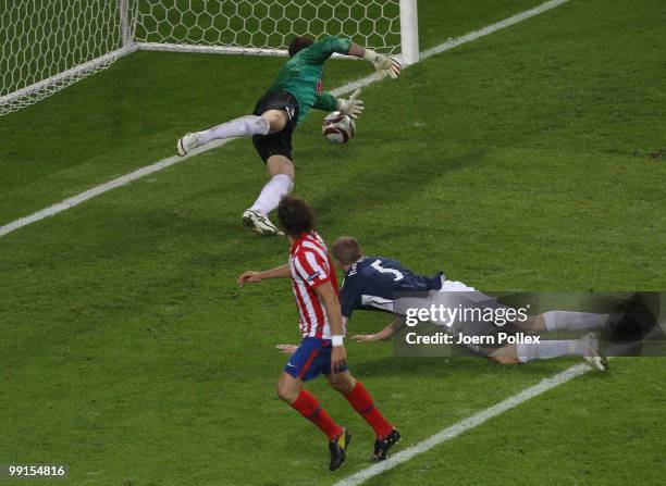 Diego Forlan of Atletico Madrid scores his team's second and winning goal against goalkeeper Mark Schwarzer of Fulham in extra time during the UEFA...