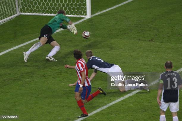 Diego Forlan of Atletico Madrid scores his team's second and winning goal against goalkeeper Mark Schwarzer of Fulham in extra time during the UEFA...