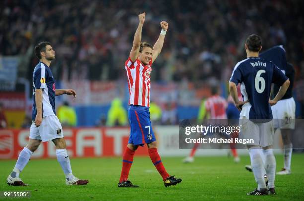 Diego Forlan of Atletico Madrid celebrates his victory while Chris Baird of Fulham looks dejected after the UEFA Europa League final match between...