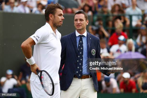 Stan Wawrinka of Switzerland speaks to the umpire as rain stops play during his Men's Singles second round match against Thomas Fabbiano of Italy on...