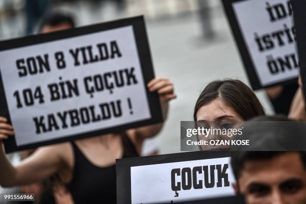 Protester holds a placard reading "104 thousand of children have been missing in the last 8 years" during a demonstration against child abuse, on...