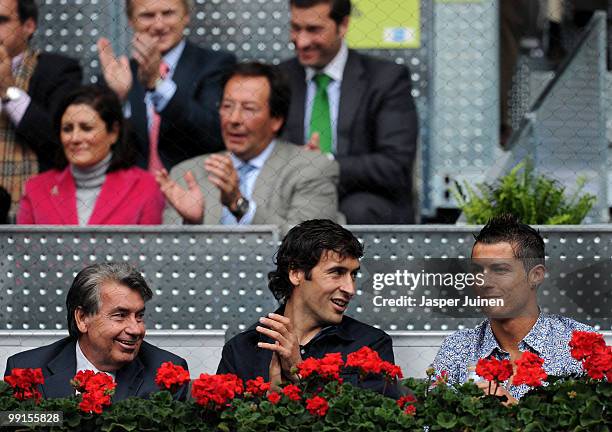 Cristiano Ronaldo and Raul Gonzalez of Real Madrid smile as they sit with former tennis champion Manolo Santana during the second round match between...