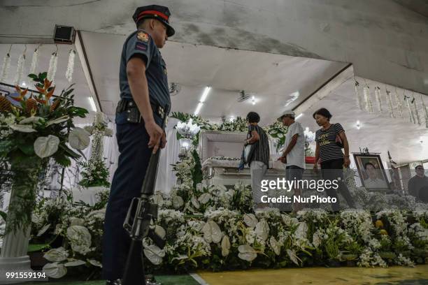 Mourners view the remains of General Tinio Mayor Ferdinand Bote, who was assassinated by unidentified gunmen on motorcycles, during his funeral wake...