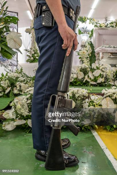 Police honour guard stands next to the remains of General Tinio Mayor Ferdinand Bote, who was assassinated by unidentified gunmen on motorcycles,...