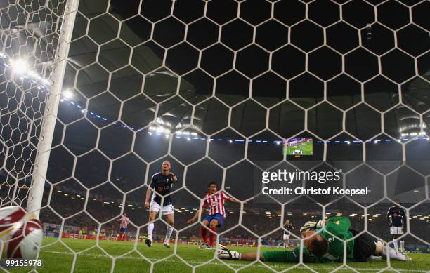 Diego Forlan of Atletico Madrid scores his team's second and winning goal against goalkeeper Mark Schwarzer of Fulham during the UEFA Europa League...