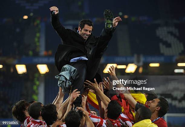 Atletico Madrid players throw their head coach Quique Sanchez Flores in the air celebrating their victory after the UEFA Europa League trophy after...