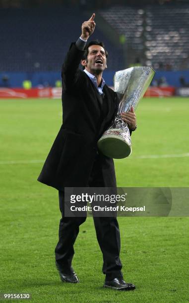Head coach Quique Sanchez Flores of Atletico Madrid holds the UEFA Europa League trophy following his team's victory after extra time at the end of...