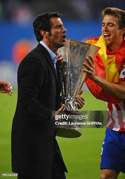 Head coach Quique Sanchez Flores of Atletico Madrid celebrates with the UEFA Europa League trophy following his team's victory after extra time at...