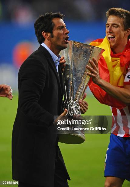 Head coach Quique Sanchez Flores of Atletico Madrid celebrates with the UEFA Europa League trophy following his team's victory after extra time at...