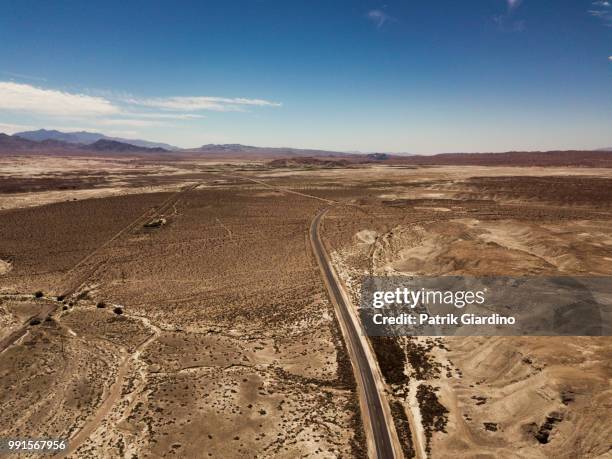 arial view of empty road in the desert - arial desert stock-fotos und bilder