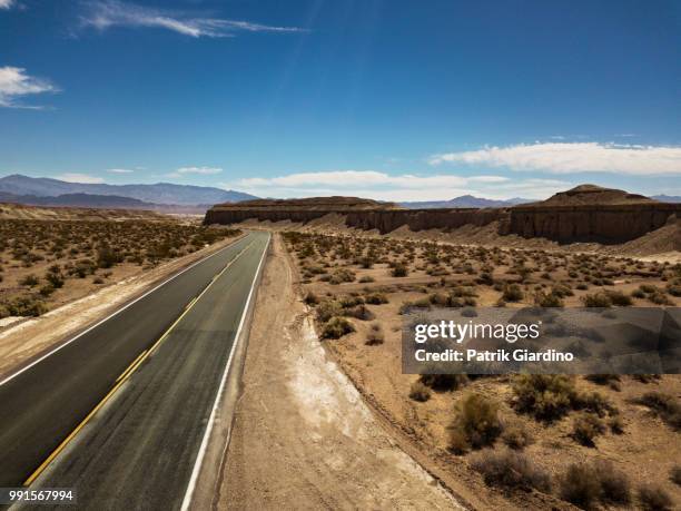 arial view of empty road in the desert - arial desert stock-fotos und bilder