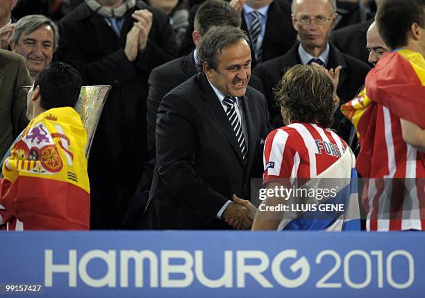 President Michel Platini congratulates Atletico Madrid's Uruguayan forward Diego Forlan after the final football match of the UEFA Europa League...