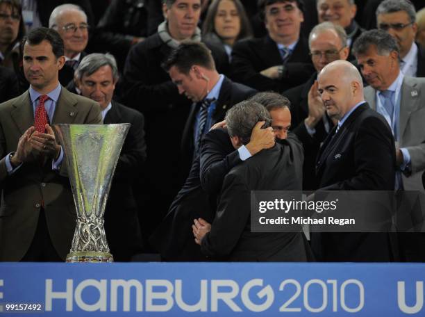 Roy Hodgson of Fulham is getting comforted by UEFA president Michel Platini next to the UEFA Europa League trophy after receiving his looser's medal...