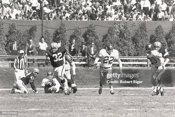 Jim Brown of the Cleveland Browns carries the ball pursued by Dick Lynch and Jimmy Patton of the New York Giants during the game at Cleveland...