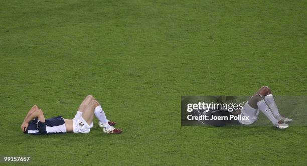 Aaron Hughes and Dickson Etuhu of Fulham lie dejected on the ground after their defeat in the UEFA Europa League final match between Atletico Madrid...