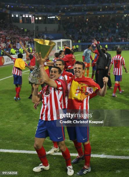Raul Garcia of Atletico Madrid and Ignacio Camacho celebrate with the UEFA Europa League trophy following their team's victory after extra time at...