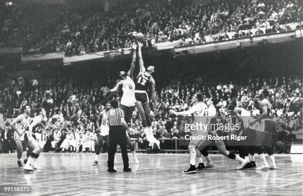 Bill Russell of the Boston Celtics tips off against Gene Wiley of the Los Angeles Lakers during a game in the 1962-63 season at the Boston Garden in...