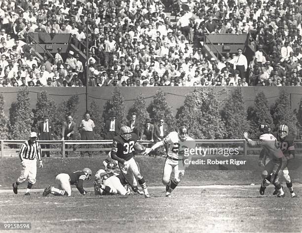 Jim Brown of the Cleveland Browns carries the ball pursued by Dick Lynch and Jimmy Patton of the New York Giants during the game at Cleveland...