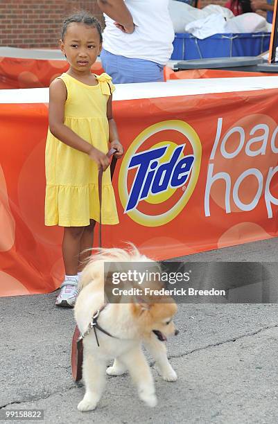 Little girl walks her dog at the Tide's Loads Of Hope mobile laundry program at Loads of Hope Truck - Laundry Drop-Off Site: Dollar General on May...