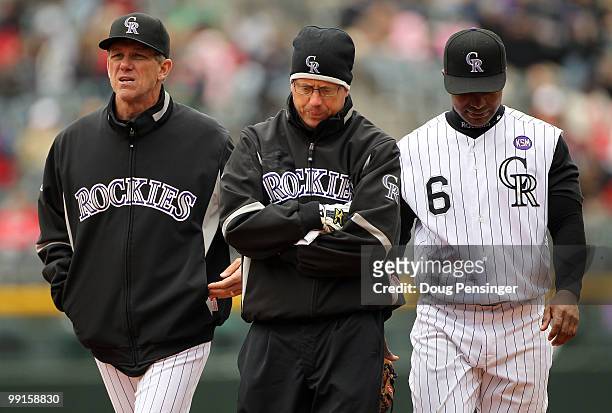 Manager Jim Tracy of the Colorado Rockies and Assistant Athletic Trainer Scott Gehret escort second baseman Melvin Mora off the field after he was...