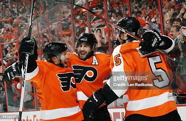 Kimmo Timonen, Simon Gagne, and Braydon Coburn of the Philadelphia Flyers celebrate a first-period goal by Mike Richards against the Boston Bruins in...