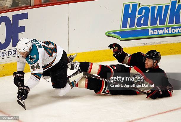 Troy Brouwer of the Chicago Blackhawks trips Marc-Edouard Vlasic of the San Jose Sharks at the United Center on December 22, 2009 in Chicago,...