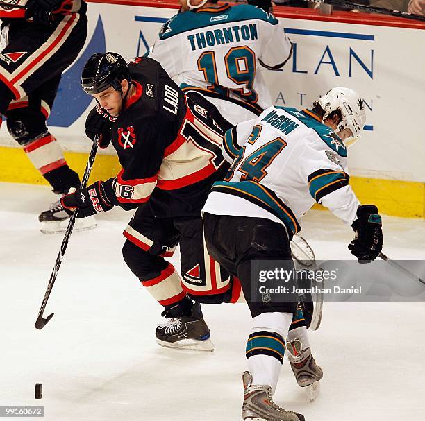 Andrew Ladd of the Chicago Blackhawks moves around Jamie McGinn the San Jose Sharks at the United Center on December 22, 2009 in Chicago, Illinois....