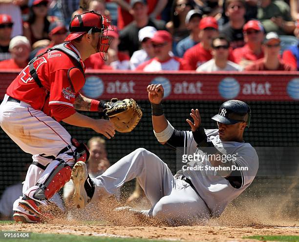Robinson Cano of the New York Yankees slides into home to score past catcher Mike Napoli of the Los Angeles Angels of Anaheim on April 24, 2010 at...