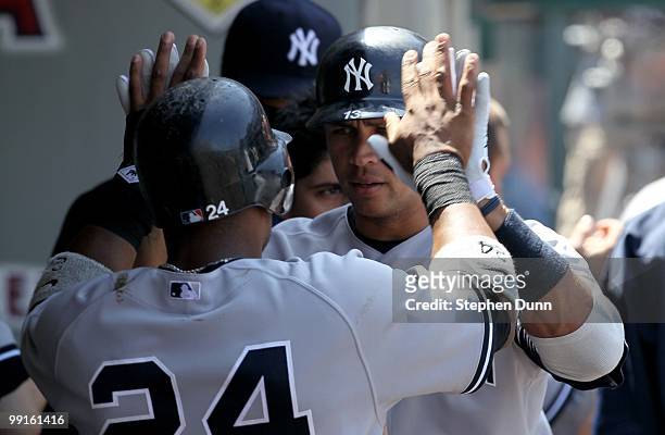 Alex Rodriguez and Robinson Cano of the New York Yankees celebrate in the dugout after both score on a Francisco Cervelli single in the fourth inning...