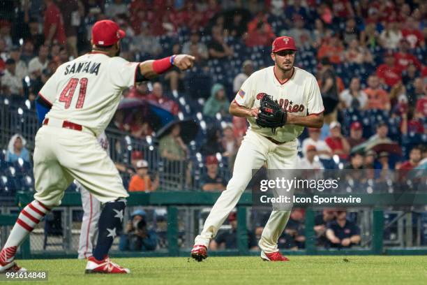 Philadelphia Phillies Pitcher Zach Eflin fields a bunt with Philadelphia Phillies First base Carlos Santana pointing to first base in the third...