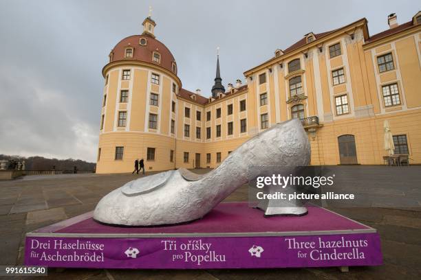 An over-sized silver shoe, part of the exhibition "Three hazelnuts for Cinderella", pictured in front of Moritzburg castle, an erstwhile hunting...