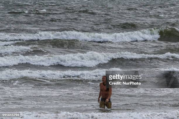 Man taking a dip in a rough sea is seen in Sopot, Poland on 30 June 2018 First weekend of summer break met tourists with very windy weather. The...