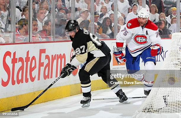 Sidney Crosby of the Pittsburgh Penguins carries the puck as Hal Gill of the Montreal Canadiens defends in Game Seven of the Eastern Conference...