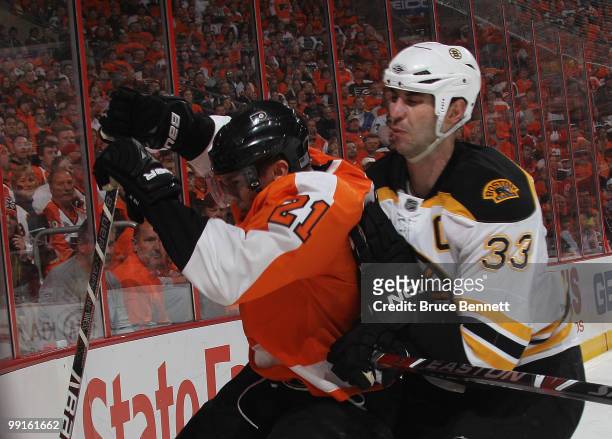 Zdeno Chara of the Boston Bruins rides James van Riemsdyk of the Philadelphia Flyers into the boards in Game Six of the Eastern Conference Semifinals...