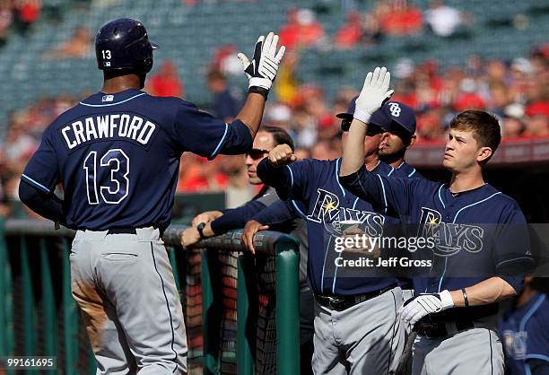 Carl Crawford of the Tampa Bay Rays receives high fives from the dugout after scoring on a past ball in the first inning against the Los Angeles...