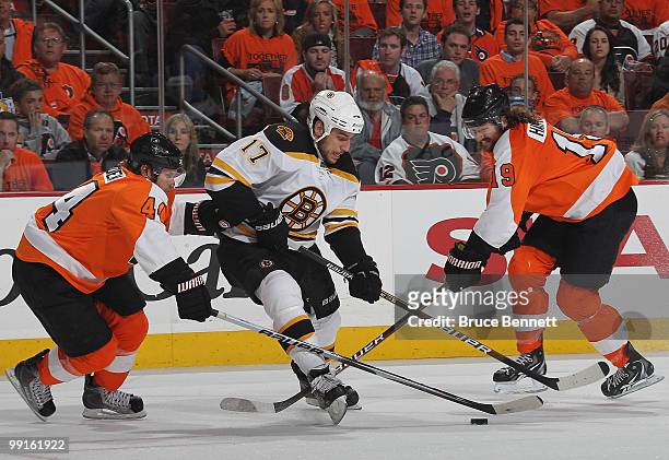 Milan Lucic of the Boston Bruins skates around Kimmo Timonen and Scott Hartnell of the Philadelphia Flyers in Game Six of the Eastern Conference...