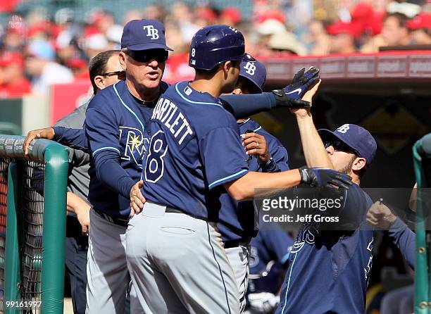 Jason Bartlett of the Tampa Bay Rays receives high fives from the dugout after scoring on a double by teammate Ben Zobrist in the first inning...