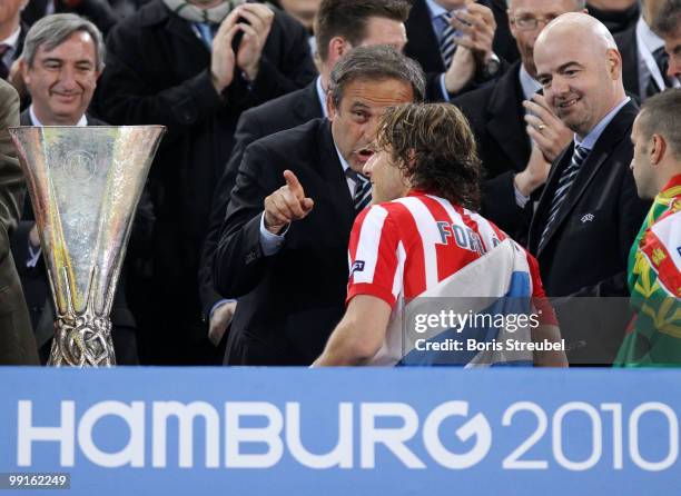 President Michel Platini congratulates Diego Forlan of Atletico Madrid at the end of the UEFA Europa League final match between Atletico Madrid and...