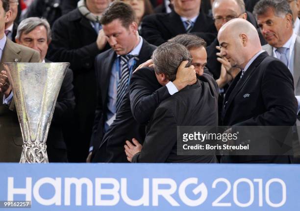Roy Hodgson of Fulham is getting comforted by UEFA president Michel Platini next to the UEFA Europa League trophy after receiving his looser's medal...